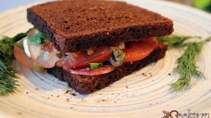 сендвич из ржаного хлеба с салями и помидором