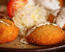 Картофельные пирожки под соусом с начинкой и овощами