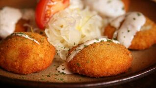 Картофельные пирожки под соусом с начинкой и овощами